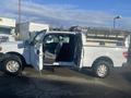 A 2013 Ford F-150 pickup truck with an open driver's side door and a utility bed in the back equipped with a foldable metal cover