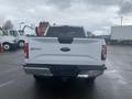 A white 2017 Ford F-150 viewed from the rear with a chrome bumper and tailgate showing the Ford logo