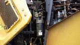 Details of the hydraulic system of a 2019 Caterpillar 972M XE showing yellow machinery components and a black oil filter labeled CAT