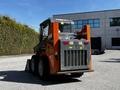 2017 Gehl R105 skid steer loader with a rear view showcasing its distinctive orange and grey design and a bucket attachment