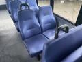 A row of blue fabric-covered seats with a plastic armrest in an empty vehicle interior