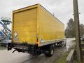 A yellow 2018 International 26 foot cube truck with air brakes parked on the side of the road facing away from the viewer