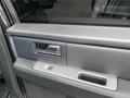 A close-up view of the door handle and control panel of a 2017 Ford Expedition interior door featuring a silver handle and window control buttons