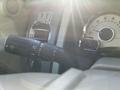 Close-up of the steering wheel controls of a 2013 Ford Expedition featuring a turn signal lever and instrument cluster with RPM gauge