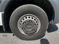 A close-up view of a wheel from a 2022 Mercedes-Benz Sprinter featuring a circular metallic rim with multiple holes and a Continental tire