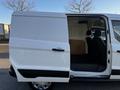 A white 2022 Ford Transit Connect van with the side door open revealing seating and cargo space inside