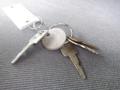 A set of keys including a round key tag with the number 612 two standard keys and a car key