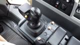 Joystick and control panel of a 2019 Caterpillar 972M XE featuring various buttons and a textured grip for machinery operation