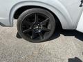 A close-up of a black alloy wheel mounted on a vintage 1962 Ford F-100 pickup truck