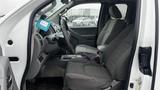 The interior of a 2016 Nissan Frontier showing two front seats with gray fabric and a center console between them