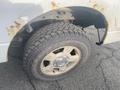 A 2009 Ford F-150 with visible rust on the wheel arch and showing a worn tire tread on the front tire