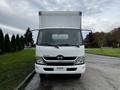 A white 2018 Hino 195 truck with a boxy cargo area and a prominent front logo facing the viewer