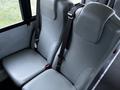 Gray upholstered bus seats with seatbelts.