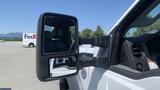 A 2011 Ford F-450 SD with an extended side mirror visible in the foreground showcasing its large dimensions and design features