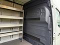 Interior view of a 2019 Mercedes-Benz Sprinter van showing metal shelving on one side and a smooth wall panel on the opposite side