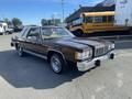 A 1982 Mercury Grand Marquis in a deep brown color with a white vinyl roof chrome accents and classic rim wheels parked at an angle