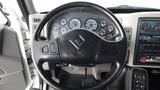 The interior view of a 2008 International 7500 featuring a steering wheel with control buttons and a dashboard displaying various gauges and controls