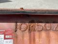 A close-up view of a rusty metal surface with the stamped numbers 10M502 and instructions visible in red and white print