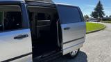 A 2016 Dodge Grand Caravan with an open sliding side door showing the interior seating area