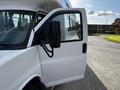 A 2015 Chevrolet Express with an open driver's side door and a side mirror clearly visible