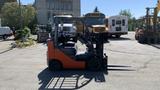 A 2018 Toyota 8FGCU25 forklift with a black and orange color scheme parked on a concrete surface