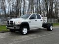 A white 2008 Dodge Ram 5500 truck with a flatbed and a single exhaust pipe stands on a paved surface