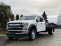 A 2022 Ford F-550 truck with a white exterior and a flatbed design parked on a surface