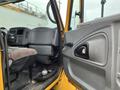 Interior view of a 2007 International 4300 truck showing the driver's seat dashboard and door panel in a yellow and gray color scheme