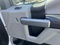 The door interior of a 2019 Ford F-350 SD featuring a gray armrest and speaker area