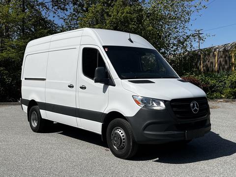 A 2022 Mercedes-Benz Sprinter van in white with a black front bumper and steel wheels parked with its side facing the viewer