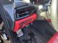 Interior view of a 2023 Acura MDX showing red and black dashboard accents and a close-up of the control panel with climate and multimedia buttons