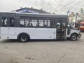 A 2017 Chevrolet Express shuttle bus with a white and black exterior and large windows, featuring an open door on the side for passenger entry