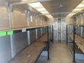 Interior of a 2006 Workhorse W42 with metal walls and wooden shelves along the sides for storage