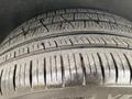 A close-up of a tire from a 2018 Jeep Grand Cherokee showing detailed tread patterns and some dust on the surface