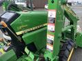 A 2003 John Deere 790 tractor featuring a green body with yellow lettering and safety warning labels on the side