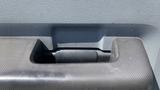 Close-up of a textured black plastic interior handle of a 2011 Ford F-450 SD with a rectangular opening for grip