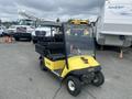 A yellow and black 2000 Ez-go Industrial 800 golf cart with a black seat and a flatbed is parked prominently in the foreground