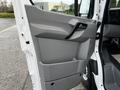 A gray door panel of a 2017 Mercedes-Benz Sprinter featuring a handle and a storage compartment