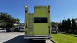 A yellow 1995 Freightliner FLL086 emergency vehicle with a rear ladder and mounted lights