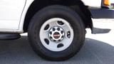 Close-up of a wheel from a 2015 GMC Savana with a silver rim and rugged tire design