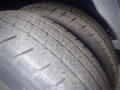 Close-up of two worn tires from a 2015 Ford Transit showing significant tread wear and dirt accumulation