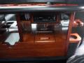 Interior view of a 2008 Cadillac Limousine showcasing a polished wooden console with cup holders and a stereo system