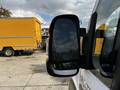 2019 RAM Promaster side mirror reflecting a cloudy sky and part of the vehicle body