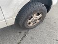 The front wheel of a 2009 Ford F-150 showing a tire with visible tread and a silver rim