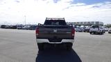 A 2014 RAM 3500 pickup truck viewed from the rear with a black exterior and a bed rack attached