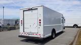 A white 2011 Ford Econoline cargo van with a large rear door and red brake lights parked in a lot