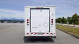 Rear view of a 2011 Ford Econoline box truck showing its white exterior and red reflective markers on the back