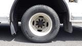 A close-up of a white wheel with a black tire from a 2011 Ford Econoline