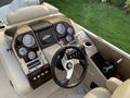 Dashboard of a 2013 Sylvan 13 person boat featuring gauges a steering wheel and control switches