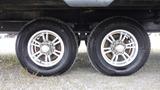 Close-up of the wheels and tires of a 2021 Forest River 312BH East To West Della Terra travel trailer showing silver rims and all-terrain tires